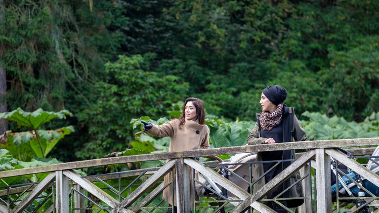 Two visitors exploring the gardens in autumn at Tatton Park, Cheshire